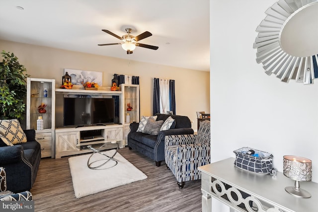 living room featuring ceiling fan and dark hardwood / wood-style floors