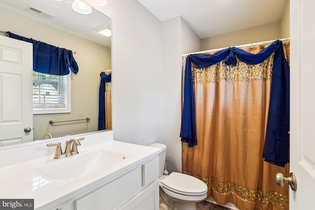 bathroom with vanity, toilet, and curtained shower