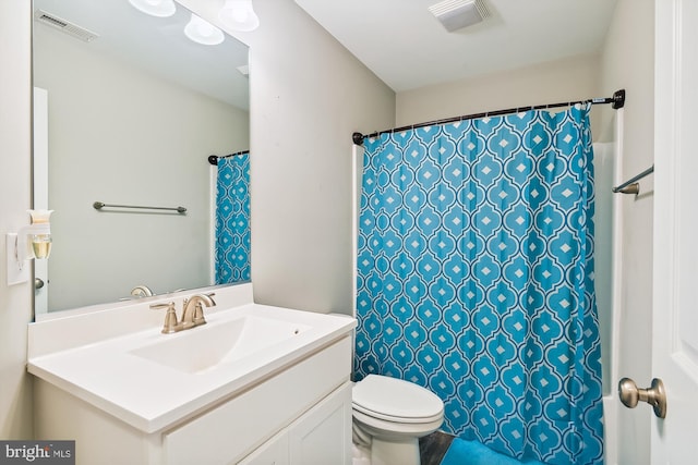 bathroom featuring curtained shower, vanity, and toilet