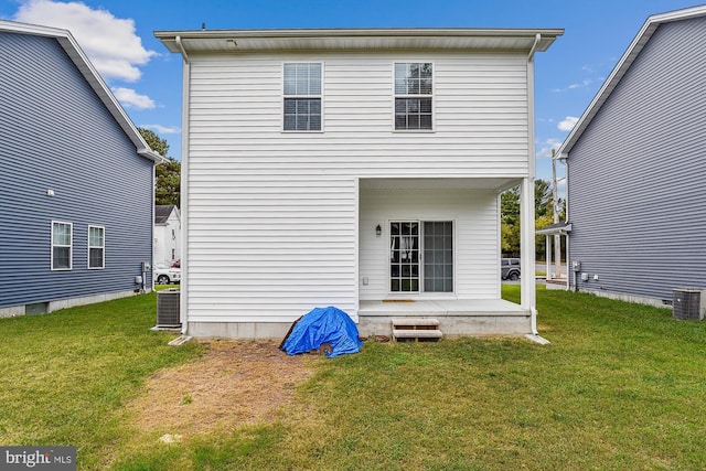 rear view of house with a lawn and central AC