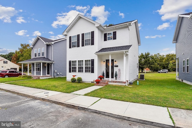 view of front of home featuring cooling unit, covered porch, and a front yard