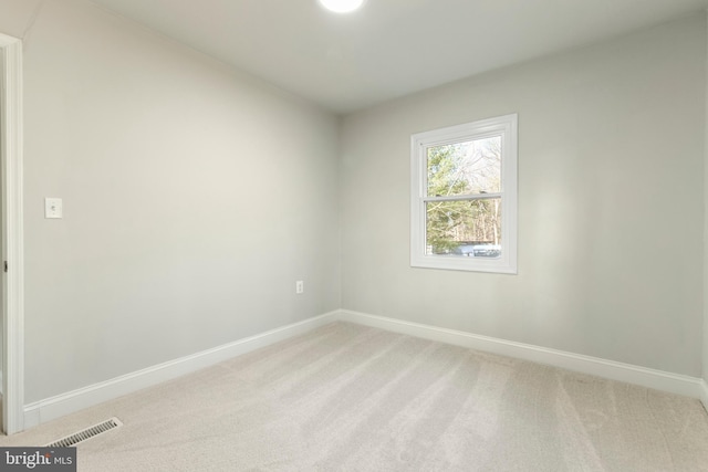 empty room featuring visible vents, baseboards, and light colored carpet