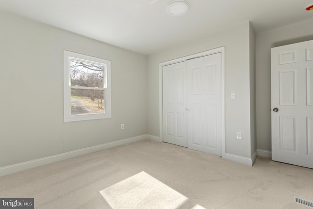 unfurnished bedroom with a closet, visible vents, carpet flooring, and baseboards