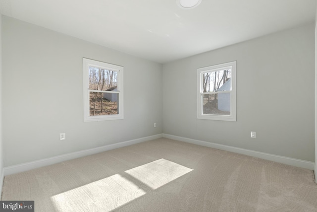 unfurnished room featuring baseboards and light colored carpet