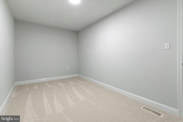 empty room with visible vents, baseboards, and light colored carpet