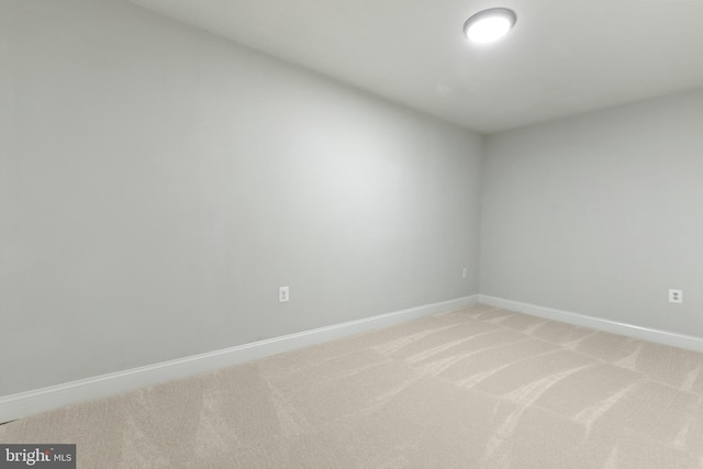 unfurnished room with baseboards and light carpet