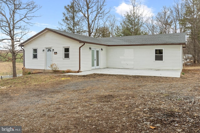 view of front of home featuring a patio, french doors, and a shingled roof