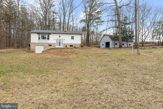 back of house with an outdoor structure and a lawn