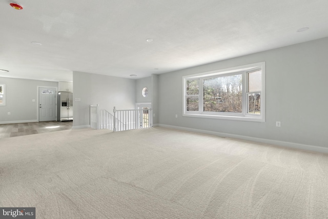 spare room with light colored carpet and baseboards