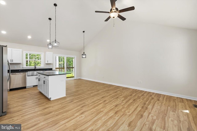 kitchen featuring white cabinets, decorative light fixtures, light hardwood / wood-style floors, and stainless steel appliances