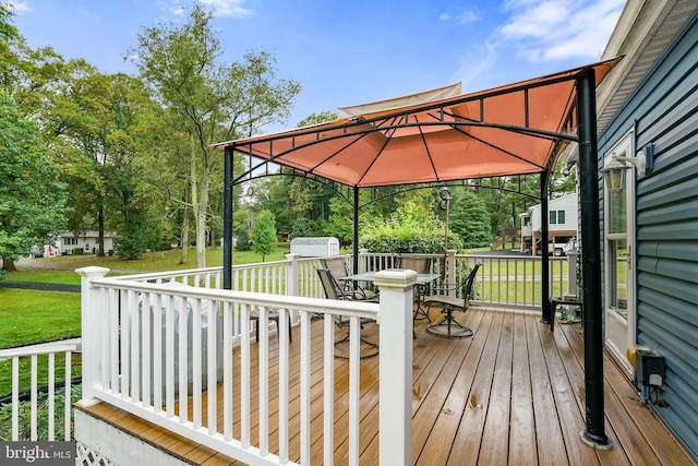 wooden terrace with a gazebo, a storage shed, and a yard