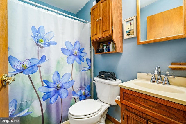 bathroom featuring curtained shower, vanity, and toilet