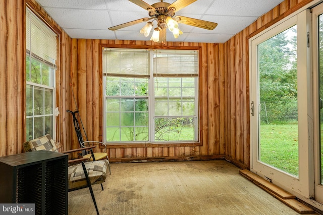 unfurnished sunroom featuring ceiling fan and a wealth of natural light