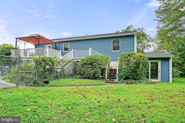 back of property featuring a wooden deck and a yard