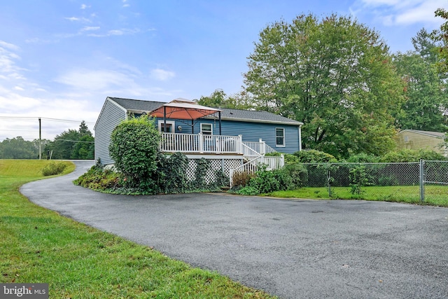 view of home's exterior featuring a lawn and a deck