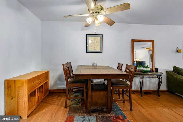 dining space featuring light wood-type flooring and ceiling fan