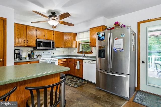 kitchen with appliances with stainless steel finishes, backsplash, sink, and ceiling fan