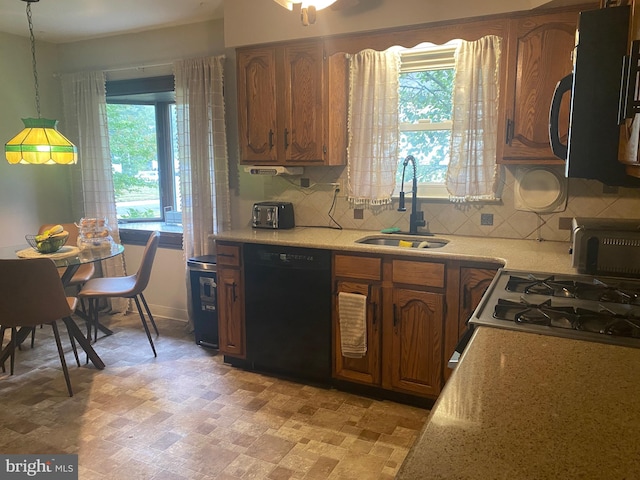 kitchen featuring pendant lighting, dishwasher, plenty of natural light, and backsplash