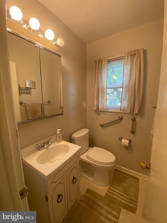 bathroom with tile patterned flooring, vanity, and toilet