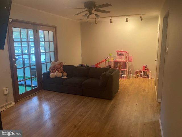 living room with ceiling fan, ornamental molding, track lighting, and hardwood / wood-style floors