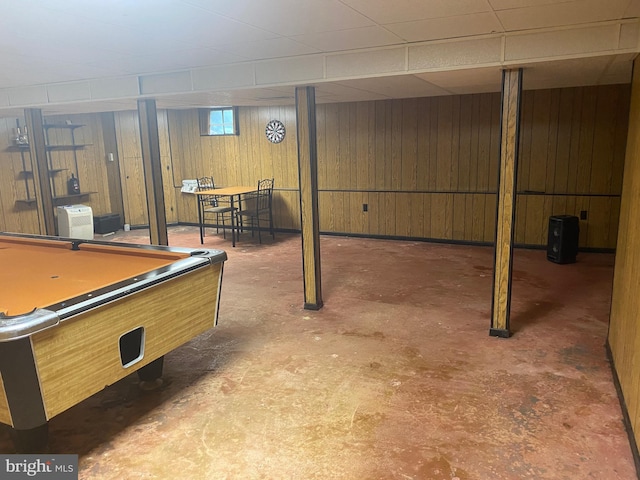 recreation room with pool table, a drop ceiling, wood walls, and concrete flooring