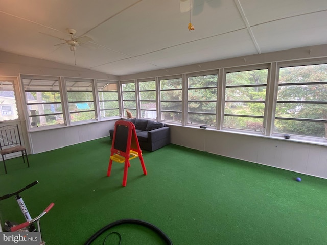 unfurnished sunroom featuring ceiling fan and a wealth of natural light