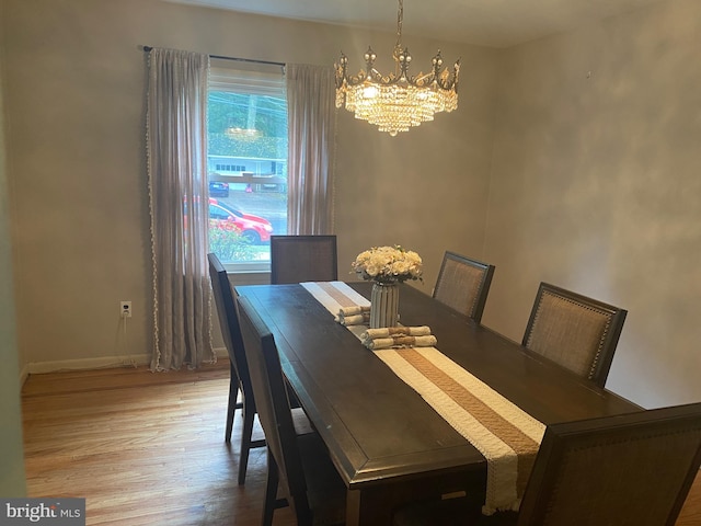 dining area featuring hardwood / wood-style flooring and a notable chandelier