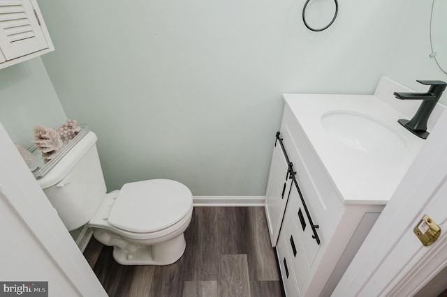 bathroom with vanity, hardwood / wood-style flooring, and toilet