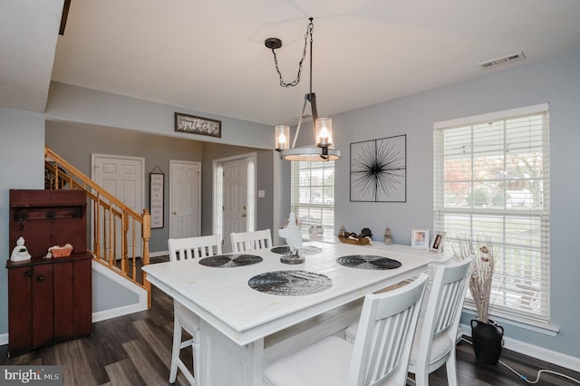 dining room featuring an inviting chandelier, dark hardwood / wood-style floors, and plenty of natural light