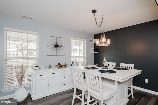 dining area featuring dark hardwood / wood-style flooring and a chandelier