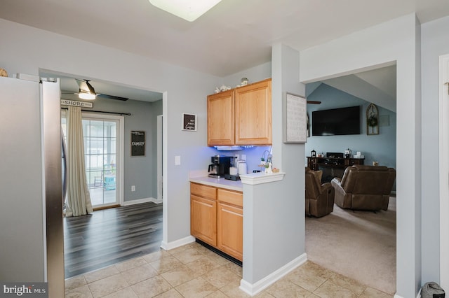 kitchen featuring light carpet and stainless steel refrigerator