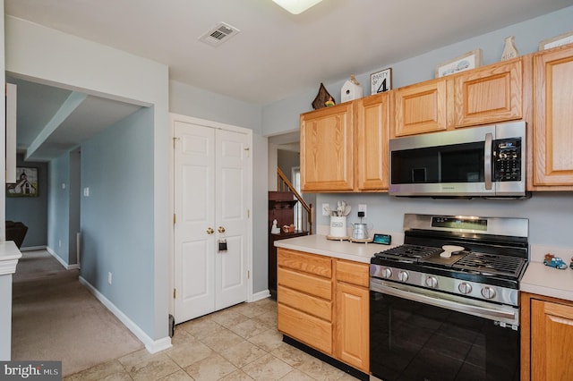 kitchen with appliances with stainless steel finishes, light brown cabinetry, and light tile patterned floors