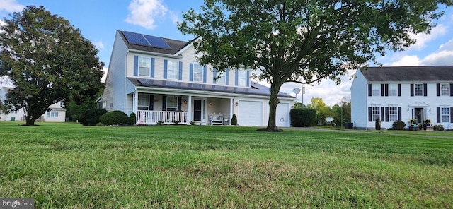 colonial house featuring solar panels, a front lawn, a garage, and a porch