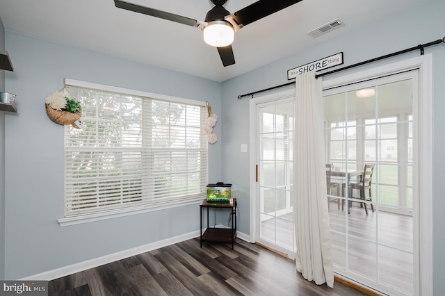 doorway with dark wood-type flooring and ceiling fan