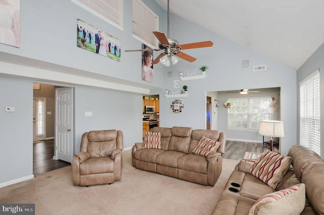 living room with hardwood / wood-style flooring, high vaulted ceiling, and ceiling fan