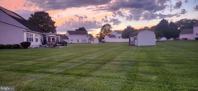 yard at dusk with a shed and a patio