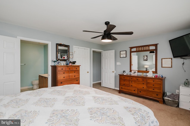 carpeted bedroom with ensuite bathroom and ceiling fan