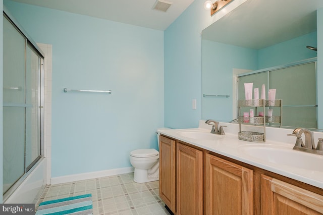 full bathroom featuring vanity, enclosed tub / shower combo, and toilet