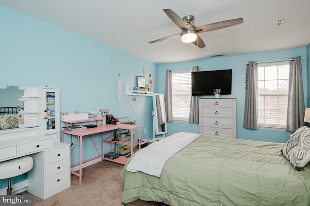 carpeted bedroom featuring multiple windows and ceiling fan