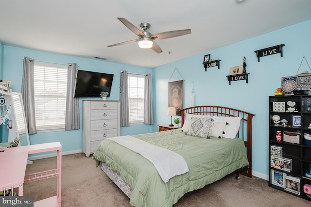 carpeted bedroom featuring multiple windows and ceiling fan