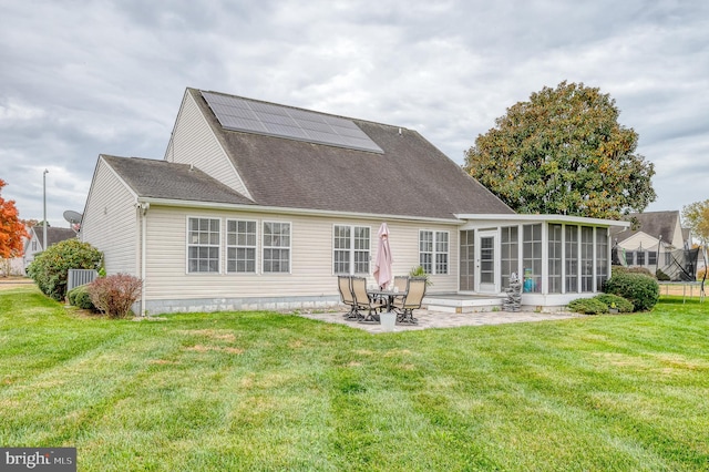 rear view of property featuring a patio area, a yard, and a sunroom