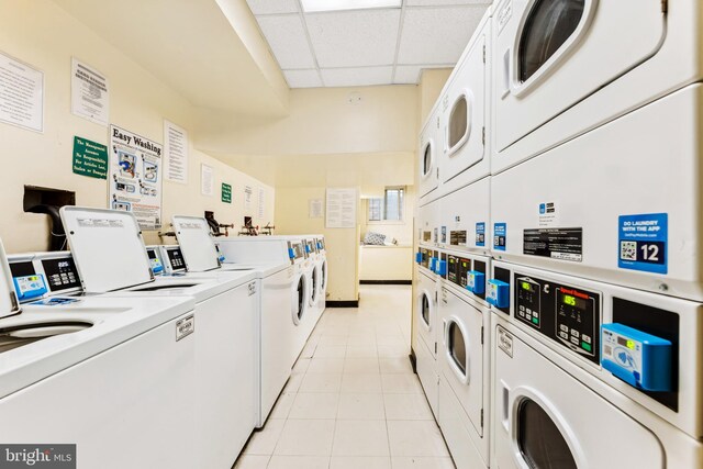 laundry area featuring stacked washer and clothes dryer, light tile patterned flooring, and washing machine and clothes dryer