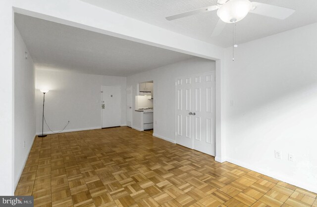 empty room featuring parquet flooring and ceiling fan