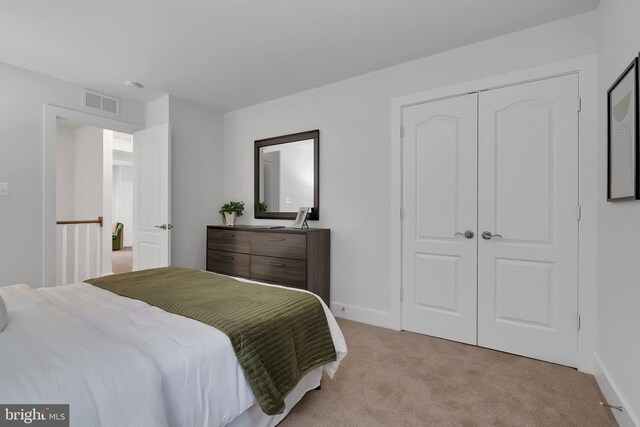 bedroom featuring light carpet and a closet