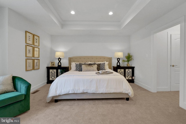 bedroom with light carpet and a raised ceiling