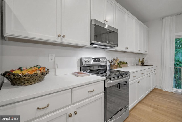 kitchen with white cabinets, appliances with stainless steel finishes, and plenty of natural light