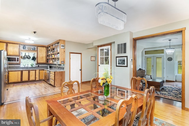 dining room with light wood-type flooring and sink