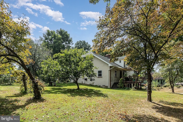 view of side of property with a lawn and a wooden deck