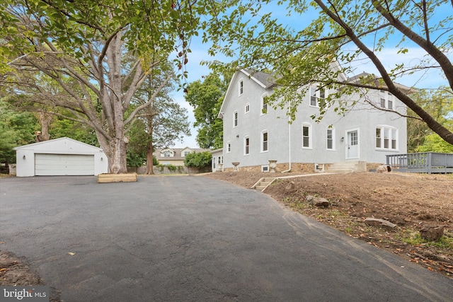 view of front of property with a garage and an outbuilding