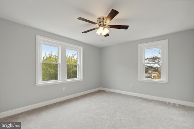 carpeted spare room with ceiling fan and a healthy amount of sunlight